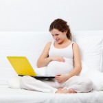 Young pregnant woman with a laptop